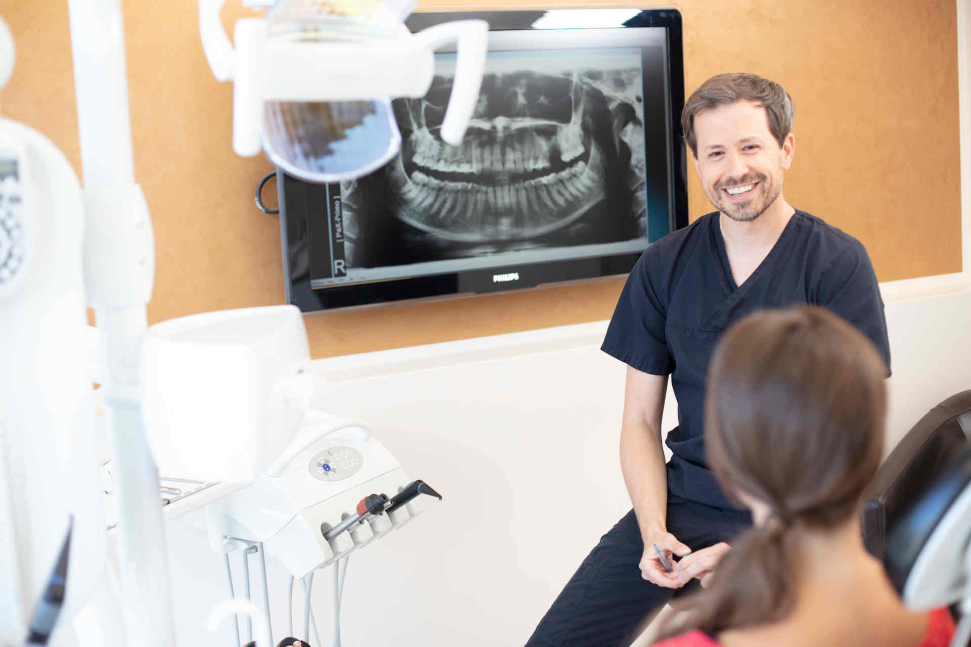 Zahnarzt erklärt Patientin den Ablauf der Behandlung