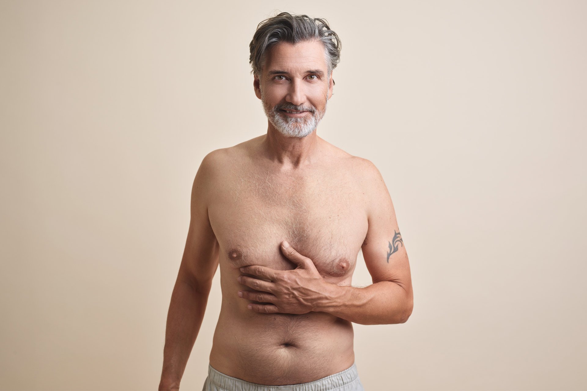mann zeigt auf seine brust vor maennerbrust entfernung