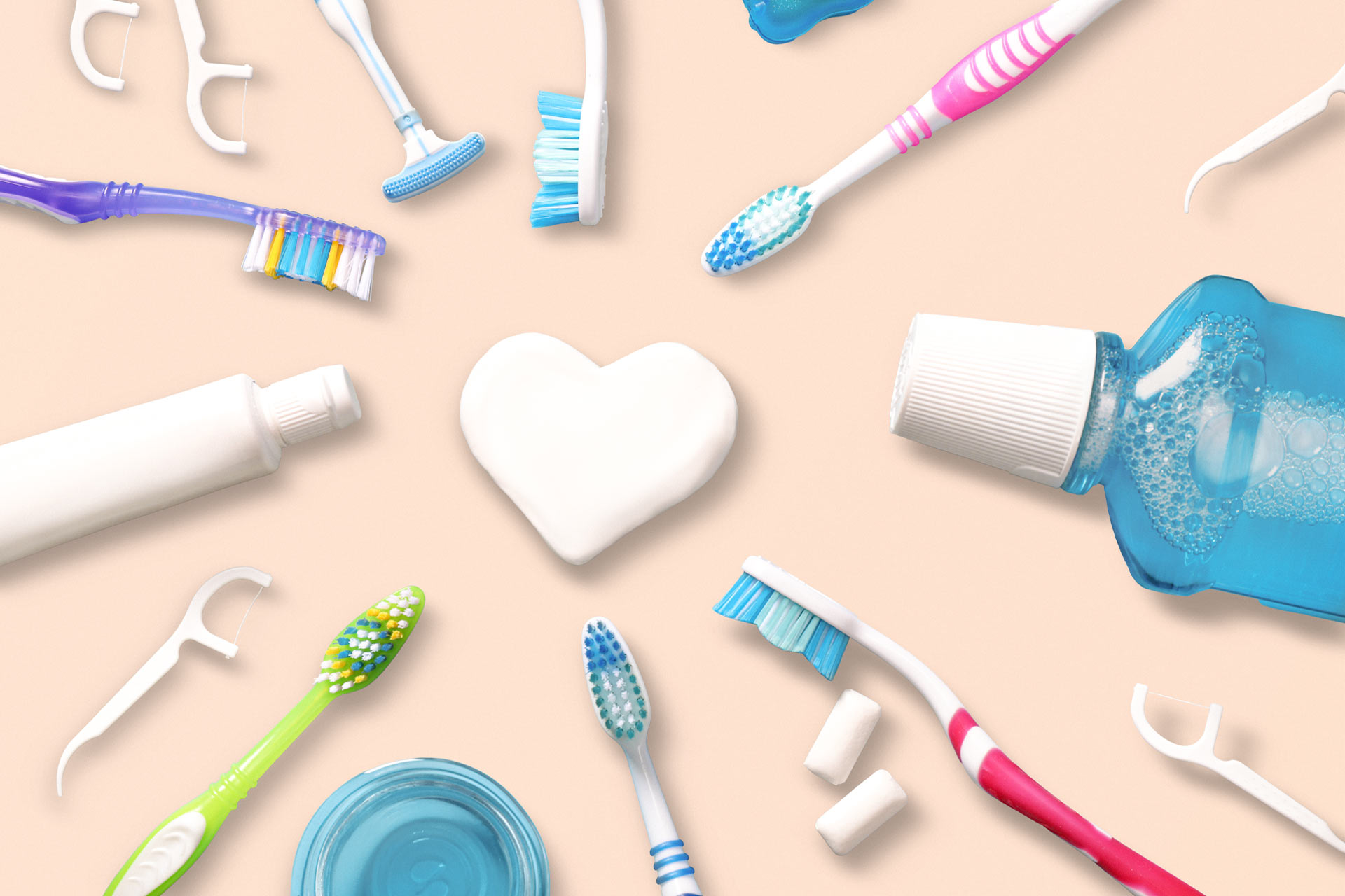 Gegenstände zur Zahnreinigung wie Zahnseide, Zahnbürtse, Mundwasser auf einem beige rosa Hintergrund