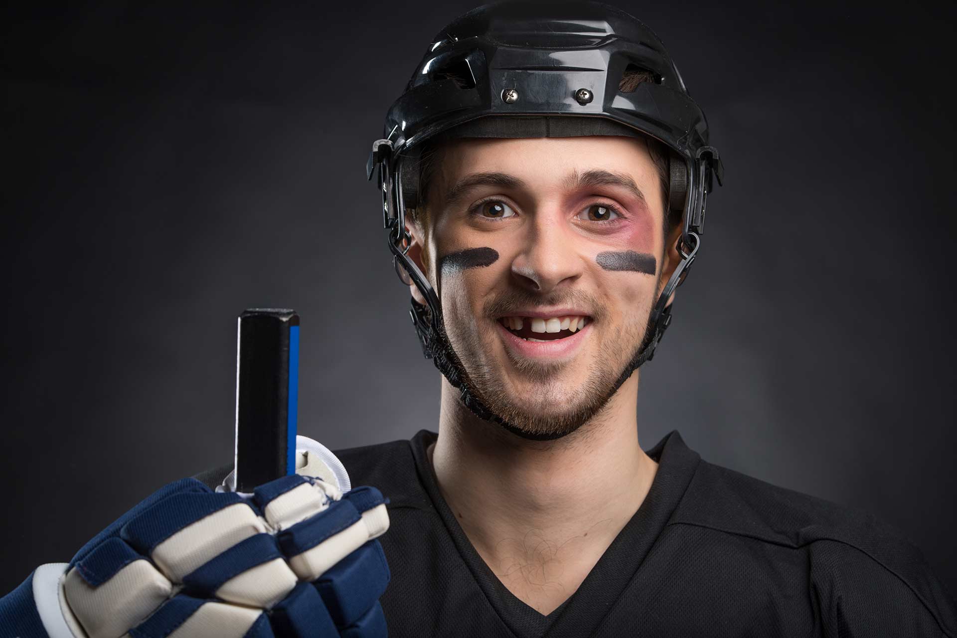 Eishockeyspieler mit fehlendem Zahn und einem lächeln im Gesicht