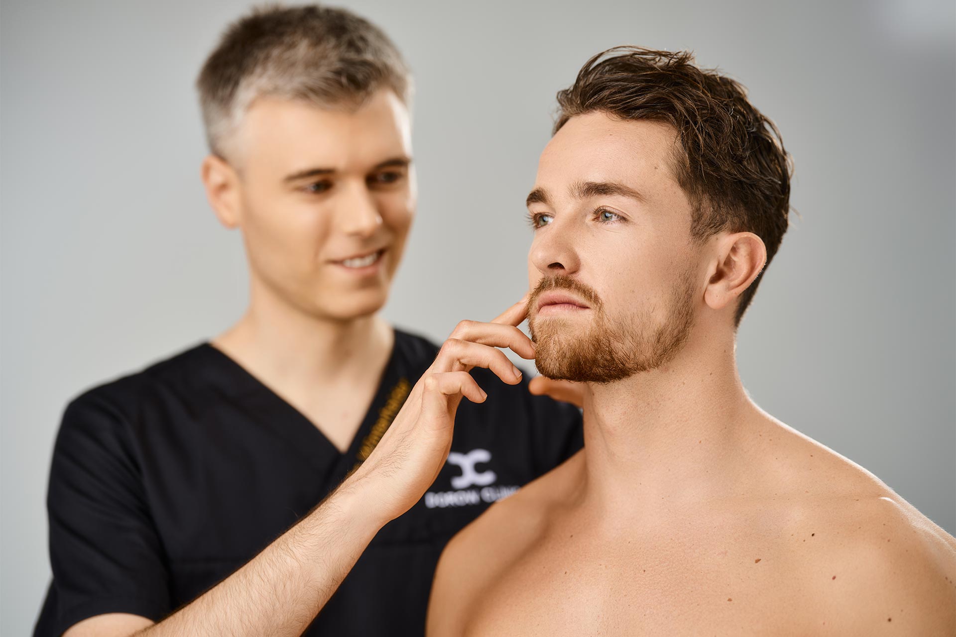 Arzt berät Mann zur Ohrläppchenvergrößerung